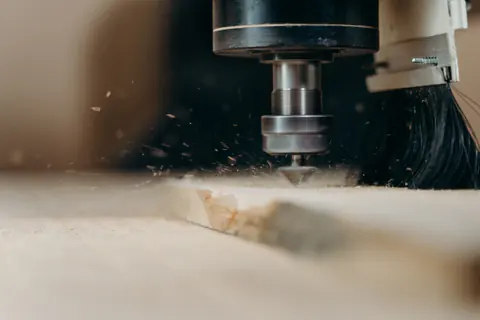 Fresa CNC mecanizando madera mientras saltan virutas