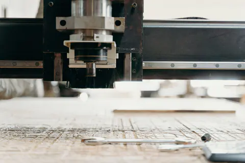 Pórtico de una fresadora CNC sobre una plancha de contrachapado cortada