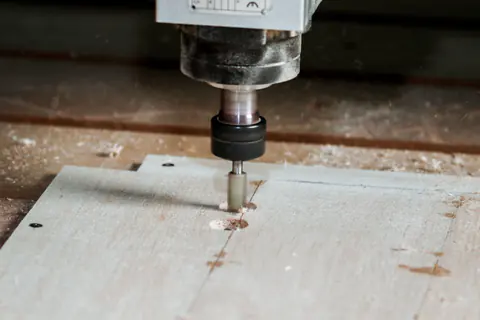 Fresa de una CNC tallando un tablero de madera